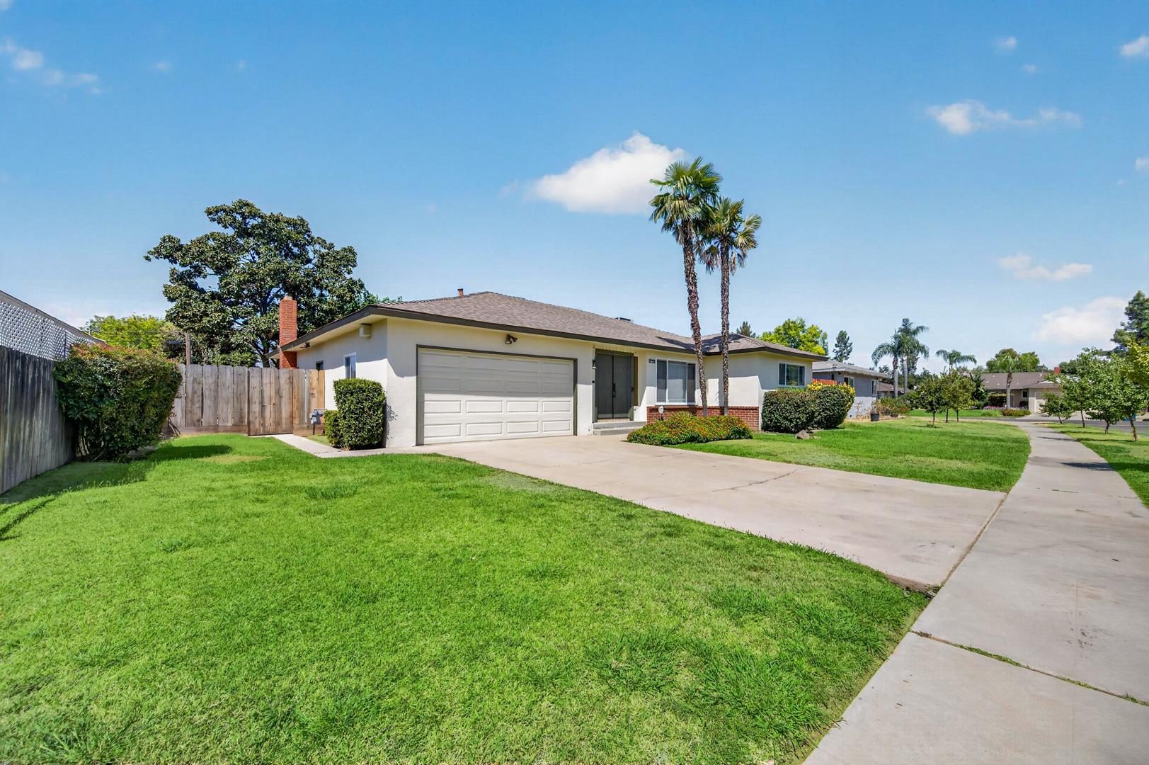 Sunlit single-story home with palms, photographed by 360 Media Drone